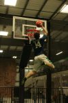 Boy in Air about to Slam Dunk on Trampoline Basketball Court